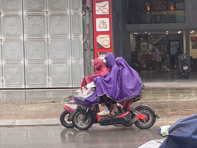 Bất chấp thời tiết, các em học sinh điểu kiển xe không đội mũ bảo hiểm, dàn hàng nói chuyện trên đường