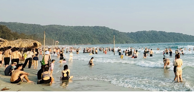 Trên bờ và dưới bãi tắm khách du lịch đến Hạ Long đông nghẹt. Ảnh: Lê Dũng