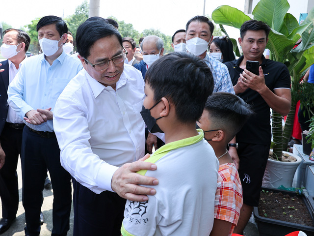 Thủ tướng thăm hỏi tình hình sinh sống của người dân tại khu nhà ở. Ảnh: VGP/Nhật Bắc