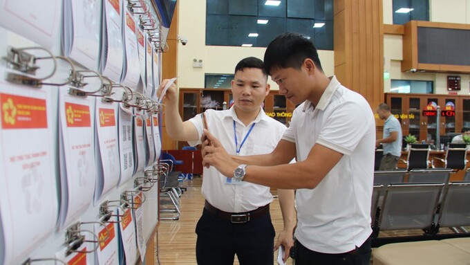 Cán bộ Trung tâm Phục vụ hành chính công tỉnh hướng dẫn người dân quét mã QR tra cứu thủ tục hành chính.