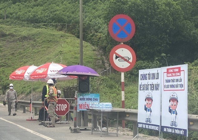 Nhân viên hầm đứng phân luồng bên cạnh lời xin lỗi được đặt đầu đường dẫn vào hầm. Ảnh lái xe cung cấp
