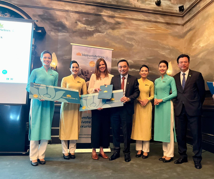 PTGĐ Lê Đức Cảnh và Trưởng CN VNA tại Anh - Phan Thế Thắng trao vé thưởng cho khách hàng may mắn tại sự kiện. Ảnh VNA