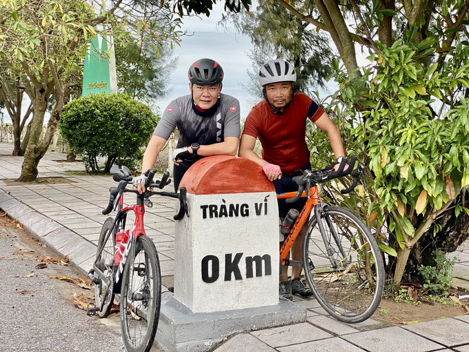 Anh Cường (Phải) và anh Sơn (Trái) check-in tại dấu mốc Tràng Vĩ. Ảnh Facebook 