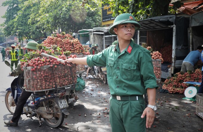 Lực lượng bộ đội đã có mặt túc trực để hỗ trợ phân luồng và điều tiết giao thông hỗ trợ bà con trở vải đi tiêu thụ một cách thuận lợi.