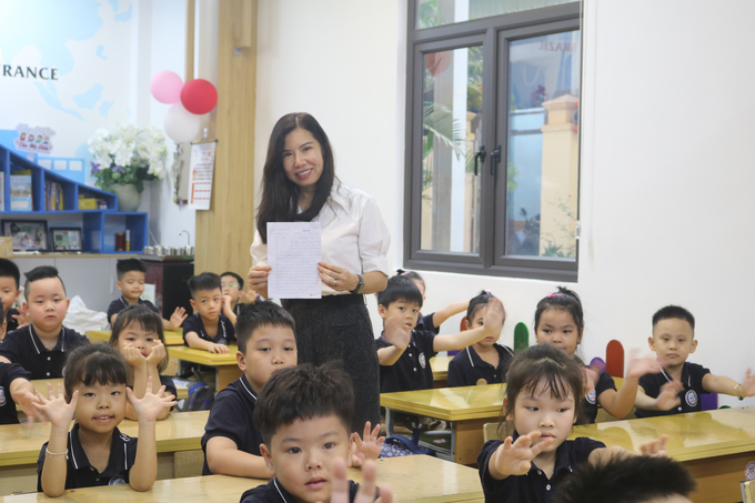 Cô giáo Nguyễn Thị Hiền xúc động 'khoe' lá thư của học trò cũ với các em lớp 1A7 hiện cô đang chủ nhiệm. Ảnh: Đinh Huyền.