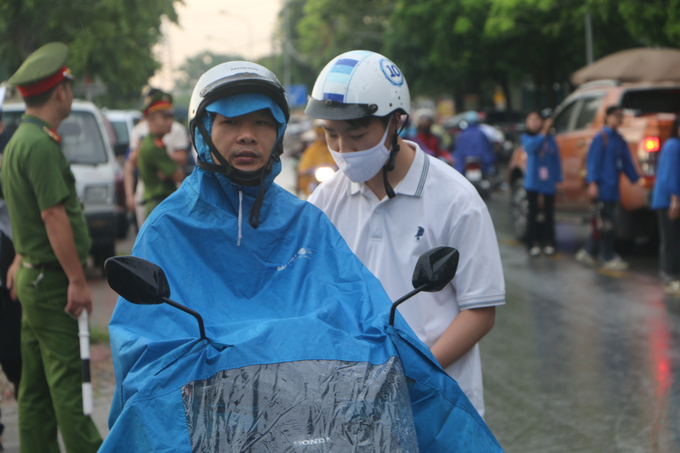 Sáng 28/6, địa bàn huyện Quốc Oai, Hà Nội có mưa nhẹ, nhiều phụ huynh cùng sĩ tử mặc áo mưa tới điểm thi