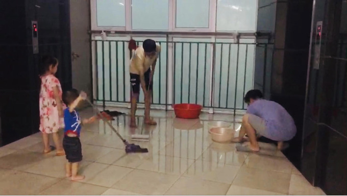 Người dân ở chung cư lau dọn khi nước thấm vào nhà