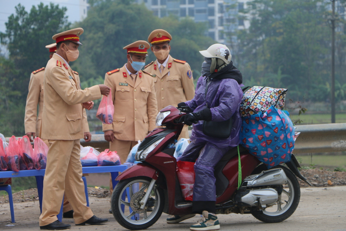 Những chai nước, chiếc bánh bao, chiếc áo mưa được các chiến sĩ chuẩn bị kỹ lưỡng, trao tận tay cho người dân