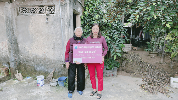 Hình ảnh cán bộ phụ nữ tại thôn đại diện cho hoàn cảnh khó khăn nhận quà