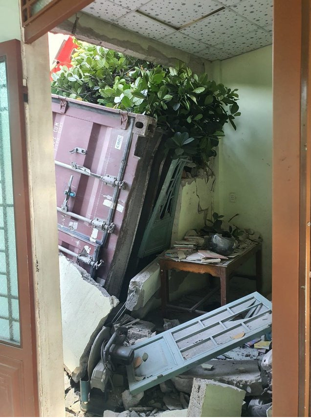 Thùng xe container đè trúng sập tường nhà dân. Ảnh: AT.