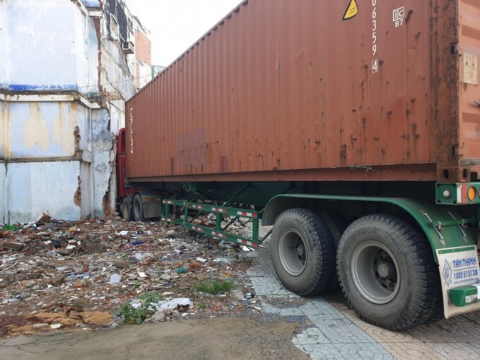 Chiếc xe container tông vào tiệm vàng bên đường.