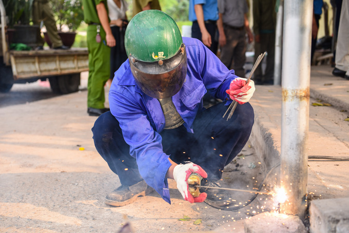 Các lực lượng chức năng tháo dỡ, ngăn chặn tình trạng lập bãi đỗ xe hàng hóa, trông giữ phương tiện trên diện tích hành lang ATGT đường bộ tại đường cao tốc Hà Nội – Bắc Giang đoạn phường Võ Cường, TP Bắc Ninh.
