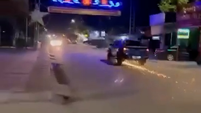 Ô tô bán tải kéo lê xe mô tô cảnh sát trên đường.