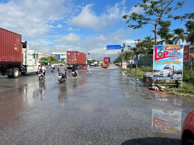 Nước ngập khiến các xe máy phải lấn ra làn đường dành cho xe ô tô rất nguy hiểm. Ảnh: ĐTP