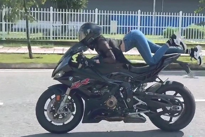 Ngọc trinh nằm trên yên xe phân khối lớn. Ảnh cắt từ clip