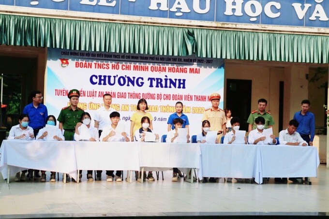 Các học sinh ký cam kết chấp hành phát luật về ATGT trước sự chứng kiến của phụ huynh, nhà trường và lực lượng chức năng