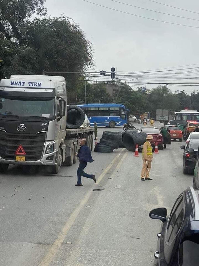 Các cuộn thép nằm ngổn ngang giữa đường, lực lượng CSGT có mặt kịp thời để xử lý vụ tai nạn giao thông. Ảnh độc giả cung cấp.