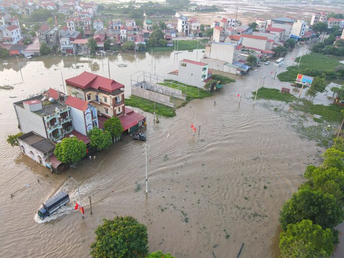 Hàng trục hộ gia đình sinh sống tại khu vực cầu Vát bị nhấn chìm trong biển nước, do mực nước tại lưu vực sông Cầu dâng cao ở mức báo động đỏ.