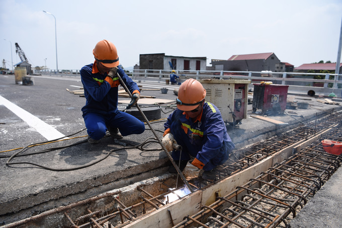 Trên công trường, dưới cái nắng như đổ lửa, công nhân vẫn miệt mài gấp rút thi công những hạng mục cuối cùng về an toàn giao thông, sơn vạch kẻ đường, khe cõ giãn.