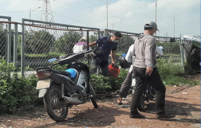 Người dân chui qua các đoạn rào chắn cao tốc bị cắt phá
