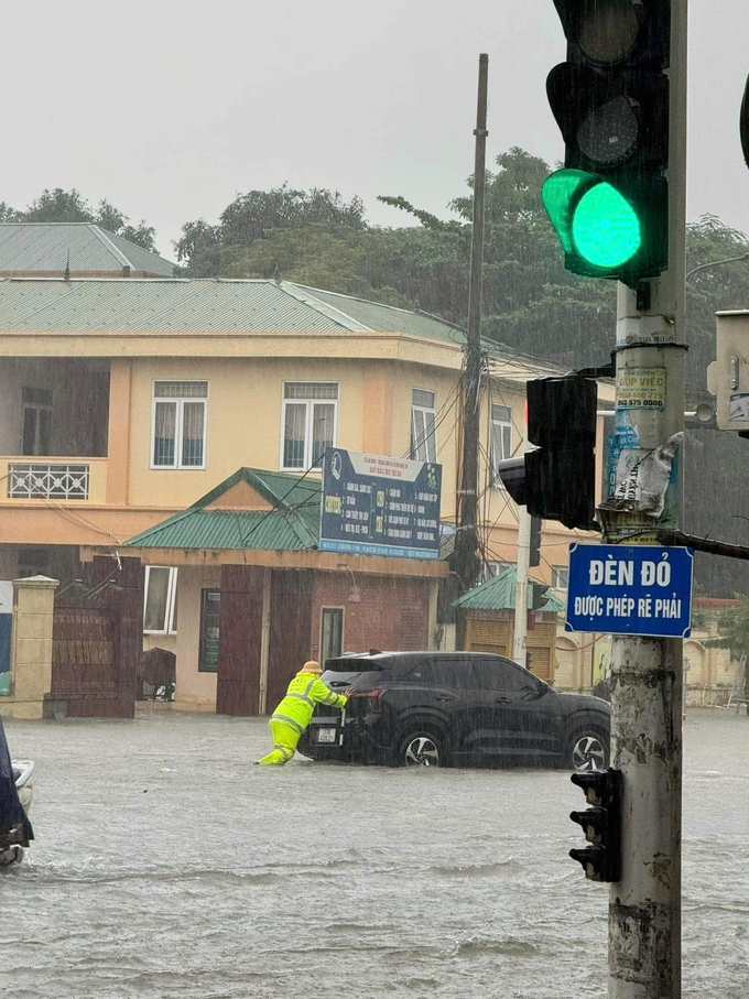 Đội CSGT TP Vinh giúp người dân đẩy ô tô chết máy do ngập sâu