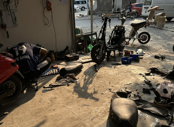 Nhân viên cửa hàng đang tháo dỡ bỏ những bộ phận xe cũ để đấu mới lại phụ tùng.